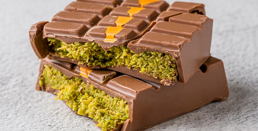 Dubai Chocolate bar with green kadayif and peanut butter on white stone table